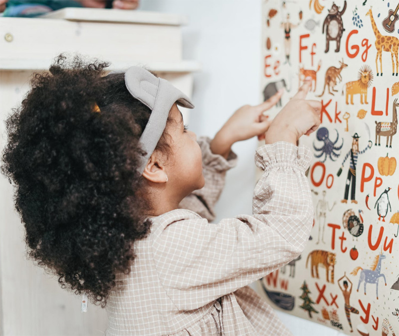 Photo of a child identifying letters and animals as a part of Volunteers of America Southwest head start & family services.