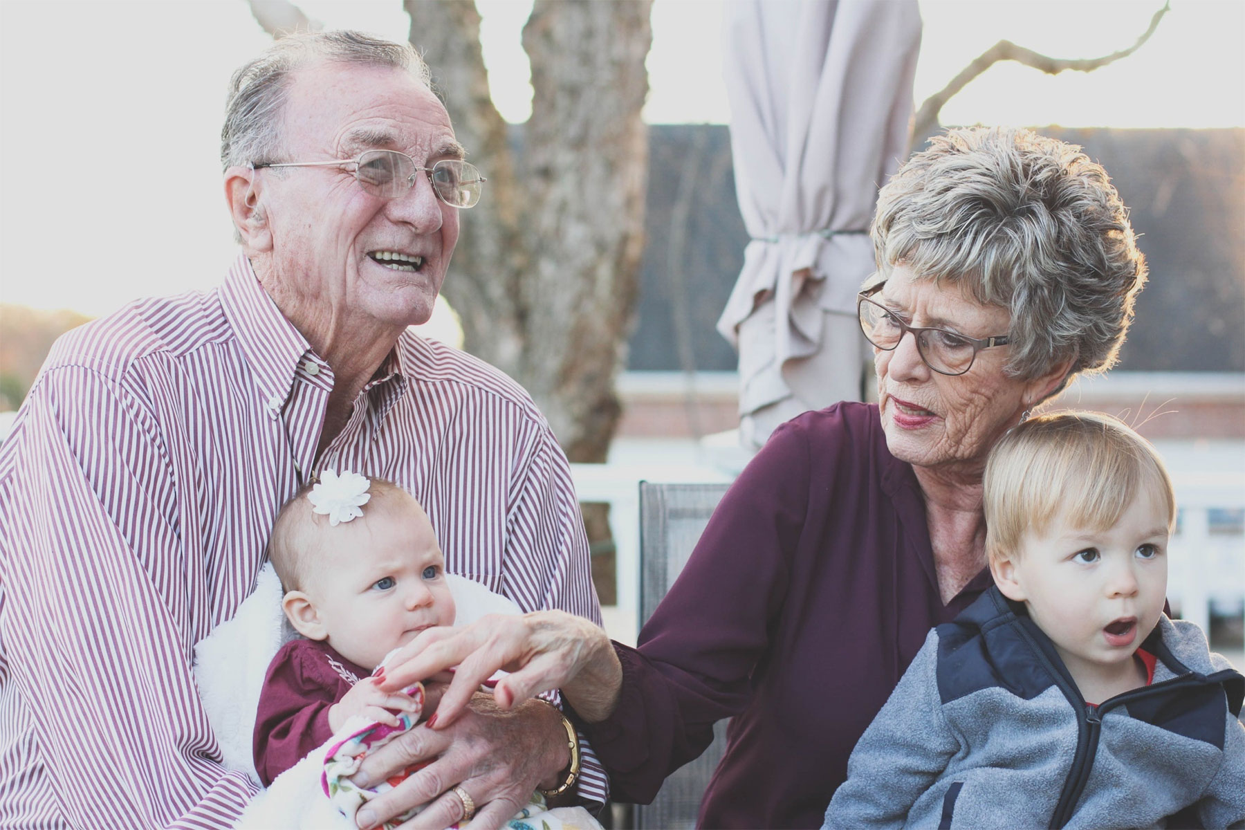 Two grandparents, a man and woman, playing with their two male grandchildren, symbolic of the legacy of planned giving to Volunteers of America Southwest.