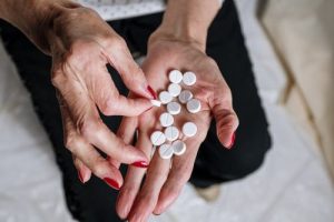 woman holding round white pills